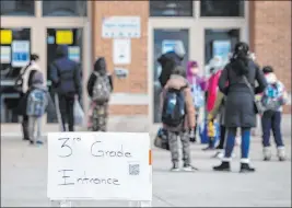  ?? Ashlee Rezin Garcia The Associated Press ?? Parents and children line up Monday outside George B. Armstrong Internatio­nal Studies Elementary School in Chicago as more students return to in-person learning.