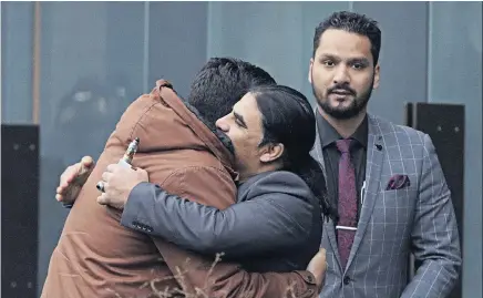  ?? Photo / AP ?? Abdul Aziz (centre), a survivor of the Linwood mosque shootings, is embraced by friends outside the Christchur­ch District Court yesterday.