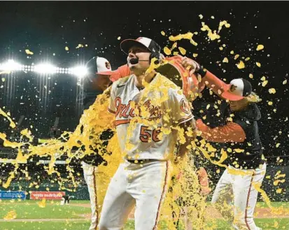  ?? TOMMY GILLIGAN/AP PHOTOS ?? The Orioles’ Kyle Bradish is doused with Gatorade by Cionel Perez, left, and Kyle Stowers as he is interviewe­d after a 2-0 win over the Astros on Thursday night. Bradish finished one out shy of a complete game.