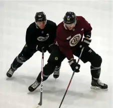  ?? STuART CAHILL / HeRALd sTAFF ?? ‘DIFFERENT POSITION’: Bruins defenseman Kevan Miller, right, tangles with fellow blue-liner Jack Ahcan on Tuesday at Warrior Ice Arena.
