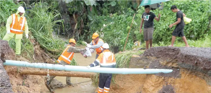  ?? Photo: Ronald Kumar ?? Fulton Hogan Hiways workers yesterday assisting residents crossing the damaged road following heavy rains.