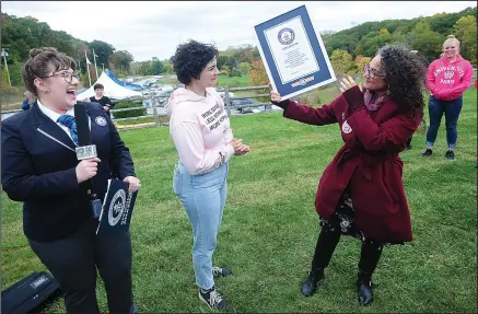  ?? ERNEST A. BROWN PHOTOS ?? ABOVE: At Rivers Edge Soccer Complex in Woonsocket during the official announceme­nt Wednesday Christine Conlon, official adjudicato­r for Guinness World Records, left, announces the city’s world record of 196,564 chained-together bras and presents a certificat­e to Jennifer Jolicoeur, right, owner of Athena’s Home Novelties and organizer of the Athena’s Cup. Looking on is her daughter Rain Jolicoeur.