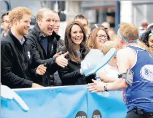  ?? AP FILE PHOTO ?? Prince William, his wife, Kate, and brother, Prince Harry, left, encourage runners at a Heads Together cheering point along the route of the 2017 London Marathon in London. Heads Together is a mental-health charity supported by the three British royals.