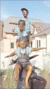  ?? LYNN KUTTER ENTERPRISE-LEADER ?? The faces of the children of a new sculpture in Farmington show the joy of playing outside and playing with friends. The sculpture can be seen in front of Farmington Village on Main Street.