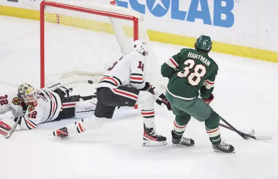  ?? STACY BENGS/AP ?? Former Blackhawk Ryan Hartman beats goaltender Alex Stalock in the third period Saturday to put the Wild up 2-1. The Hawks lost their fourth in a row.