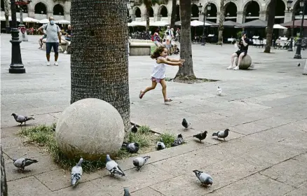  ?? ANA JIMÉNEZ ?? Bola adossada en una palmera i, al fons, un turista reposant en una esfera sobre la tapa del claveguera­m