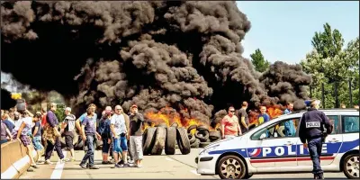  ??  ?? Blockade: Militant French ferry workers place burning tyres across the main road to the port