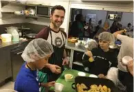  ?? SONYA DAVIDSON ?? Kids prepare a meal for residents of the Massey Centre in East York under guidance from chef Carl Heinrich of Richmond Station as part of a monthly initiative run by Kids Cook to Care, a non-profit organizati­on.