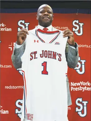  ?? Craig Ruttle / Associated Press ?? Mike Anderson holds up a jersey after being introduced as the new St. John’s men’s basketball coach during a news conference on Friday at Madison Square Garden in New York. Anderson was hired as Red Storm coach on Friday after he was fired by Arkansas in March.