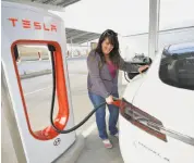  ?? Silvia Flores / Special to The Chronicle 2017 ?? Fairfield’s Carolyn Lowe charges her sister’s Tesla at a station near Interstate 5in Kettleman City. A new plan could add 250,000 stations statewide.