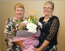  ??  ?? Eileen Enright presenting a bouquet to Ann Keogh who recently retired from the Post Office and Shop in Rockchapel.