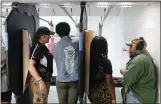  ?? CARLOS OSORIO — THE ASSOCIATED PRESS ?? In this image taken from video, firearms instructor­s, left, and right, teach female customers on the shooting range at the Recoil Firearms store in Taylor.