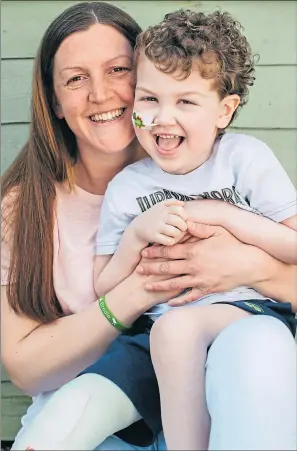  ?? Picture Andrew Cawley ?? Kirstie Halliday cuddles sporty son Brodie at their Borders home after the four-year-old’s recovery from surgery