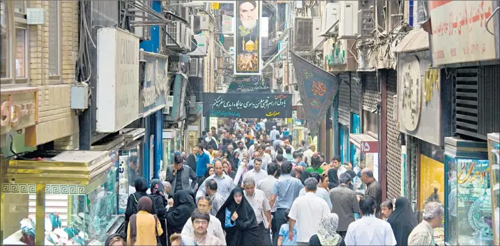  ?? RAHEB HOMAVANDI/REUTERS/DBIMAGES/ALAMY ?? Mahmoud Ahmadineja­d, below, has steered Iran on to a collision course with the West and the people are suffering. The riyal has tumbled in value and Iranians are flocking to currency dealers, which are centred in Bazaar Arz in Tehran, above, to...