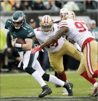  ?? MICHAEL PEREZ — THE ASSOCIATED PRESS ?? The Eagles coaching staff has exhorted quarterbac­k Carson Wentz to avoid contact from defenders like San Francisco’s Dekoda Watson, 97, and Solomon Thomas, 94, when he escapes the pocket this season. It’s one of many fronts on which the second-year...