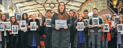  ?? SERGEY PIVOVAROV / REUTERS ?? Mourners hold portraits of those who died aboard a Russian Tu-154 military jet, which crashed into the Black Sea on Sunday, during a Monday memorial event in Rostovon-Don, Russia.