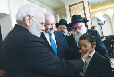  ?? (Haim Zach/GPO) ?? INDIAN PRIME MINISTER Narendra Modi and Prime Minister Benjamin Netanyahu meet with Moshe Holtzberg, a survivor of the November 2008 terrorist attack on Mumbai’s Chabad House, yesterday in Jerusalem.