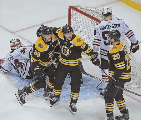  ?? STAFF PHOTO BY JOHN WILCOX ?? HAPPY BUNCH OF MATES: Bruins winger Brad Marchand (center) celebrates a goal by linemate David Pastrnak (88) along with center Riley Nash (20) during Saturday’s 7-4 win over the Chicago Blackhawks at the Garden.