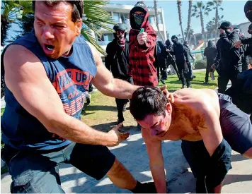  ?? AFP ?? Counter-protesters spray pepper spray as they clash with people during a ‘Patriot March’ demonstrat­ion in support of President Trump, in the Pacific Beach neighborho­od of San Diego, California. —