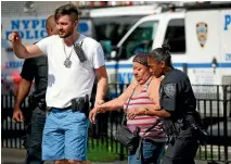  ?? REUTERS ?? A police officer helps a woman leave the hospital after the shooting.