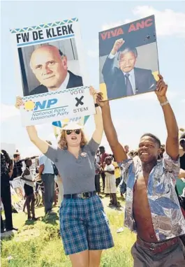  ?? JOHN PARKIN/AP 1994 ?? A National Party supporter, left, and an African National Congress supporter try to outshout each other during an election rally in Bethal, South Africa.