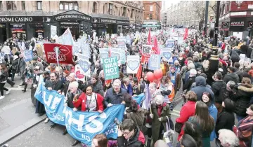  ??  ?? Protesters march with banners and placards against private companies’ involvemen­t in the National Health Service (NHS) and social care services provision and against cuts to NHS funding in central London. — AFP photo