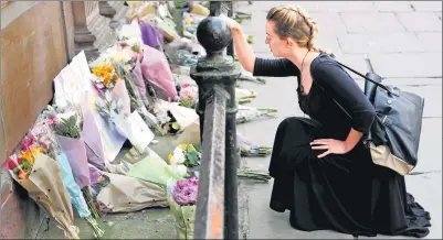  ?? DARREN STAPLES / REUTERS ?? A woman places flowers on Tuesday for victims of Monday night’s Manchester Arena bombing attack.