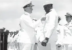  ?? COURTESY OF US NAVY ?? Admiral Chester W. Nimitz pins the Navy Cross on Doris Miller, at a ceremony on board the USS Enterprise (CV-6) at Pearl Harbor on May 27, 1942. Miller was one of 646 sailors who lost their lives when a Japanese submarine attacked and sank Liscome Bay.