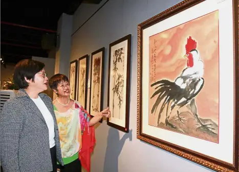  ??  ?? Work of art: Chew (left) browsing through paintings as Malaysian Artists Society president Shirley Chu briefs her after the launch of the Malaysian-Korean Renowned Artists Exchange Exhibition at Longhua Museum in Serdang.