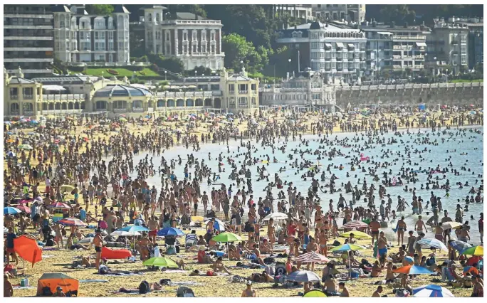  ?? — AP ?? Hot as blazes: People crowding La Concha beach in the basque city of San Sebastian, northern Spain.