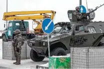  ?? Associated Press ?? A Kazakhstan soldier guards a checkpoint Friday as Russia deploys 70 cargo planes to help quell widespread rioting.