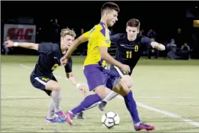  ?? Photo submitted ?? John Brown sophomore Elias McCloud, middle, battles Science and Arts (Okla.) defenders Bjarne Deraeve, left, and Hugo Medrano for possession of the ball during Tuesday’s Sooner Athletic Conference Tournament semifinal match in Chickasha, Okla. The Drovers won the match 4-1 to end JBU’s season.