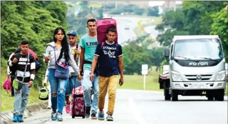  ?? RAUL ARBOLEDA/AFP ?? Venezuelan migrants walk in Colombia, on Sunday. Juan Guaido, recognised by some 50 countries as Venezuela’s interim president, warns the military that blocking humanitari­an aid from entering the country is a ‘crime against humanity’.