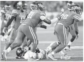  ?? Elizabeth Conley / Houston Chronicle ?? Rice quarterbac­k Sam Glaesmann, bottom, was mistreated by Houston on Saturday, eventually exiting with a shoulder injury that will sideline him this weekend against Florida Internatio­nal.