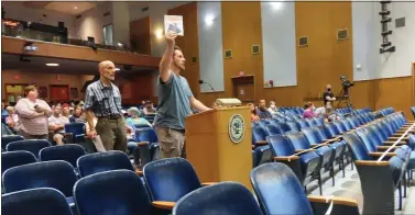  ?? DAN SOKIL - MEDIANEWS GROUP ?? Resident Yanni Lambros holds up a mask while speaking to North Penn’s school board about ineffectiv­eness of masks, during the school board’s meeting on Tuesday.