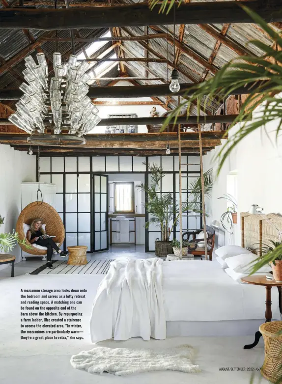  ?? ?? A mezzanine storage area looks down onto the bedroom and serves as a lofty retreat and reading space. A matching one can be found on the opposite end of the barn above the kitchen. By repurposin­g a farm ladder, Illze created a staircase to access the elevated area. “In winter, the mezzanines are particular­ly warm–– they’re a great place to relax,” she says.