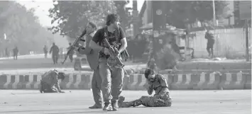  ?? ASSOCIATED PRESS ?? Afghan security personnel stand guard next to wounded comrades at the site of an attack near the Kabul Internatio­nal Airport in Afghanista­n, shortly after the country's controvers­ial first vice president Gen. Abdul Rashid Dostum landed on his return...