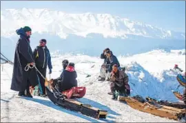  ?? Idrees Abbas SOPA Images ?? SLEDDERS wait at a ski resort in the Kashmir region of India, one of the geopolitic­al f lashpoints in the Himalayas and an area also undergoing climate stress.