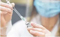  ?? AZIN GHAFFARI • POSTMEDIA NEWS ?? Pharmacist Alison Davison prepares a dose of Pfizer-biontech COVID-19 vaccine at Shoppers Drug Mart pharmacy on March 5.