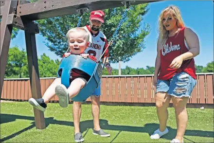  ??  ?? Derek and Karis House of Yukon watch their son, Everton Baker, enjoy a swing ride at Yukon City Park on July 19. Everton Baker is named after former OU quarterbac­k Baker Mayfield. [PAXSON HAWS/ THE OKLAHOMAN]