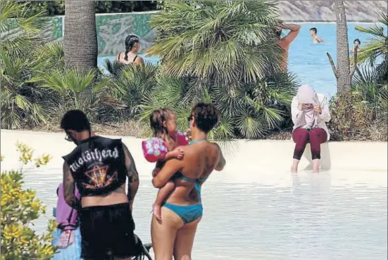  ?? PERE DURAN / NORD MEDIA ?? Una mujer musulmana se refrescaba ayer, vestida y descalza, en una de las piscinas del parque acuático de Aquabrava