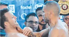  ??  ?? SURPRISE: Anthony Mundine grabs Jeff Horn at their weigh-in.