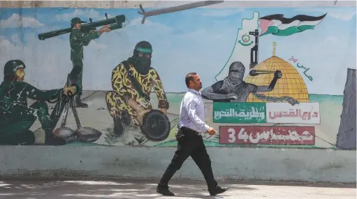  ?? (Abed Rahim Khatib/Flash90) ?? A MURAL in Khan Yunis, Gaza Strip, depicts Hamas fighters firing rockets.