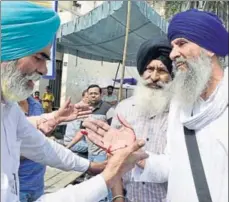  ?? SAMEER SEHGAL /HT ?? SGPC task force members clashing with radical Sikh activists at the Golden Temple, Amritsar, on Thursday; an activist who was injured showing his hand.