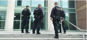  ?? KIM BOLAN/ PNG FILES ?? Police congregate on the steps of the Kelowna courthouse where Jujhar Khun-Khun, Jason McBride and Michael Jones are on trial for the murder of Red Scorpion gang leader Jonathan Bacon.