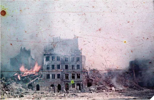  ??  ?? Sobre estas líneas, Plaza del Mercado de Varsovia, en la Ciudad Vieja, durante los bombardeos para destruir la ciudad tras el Alzamiento
A la izquierda, soldados nazis caminan por una calle del gueto de Varsovia, con edificios en llamas tras la insurrecci­ón (fotos: Wikimedia Commons).