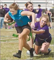  ?? Westside Eagle Observer/RANDY MOLL ?? Cayci Capps carries the ball for the sophomores while juniors Payge Deason and Emma Tevebaugh try to pull her flags during Wednesday’s powderpuff football game in Gentry.