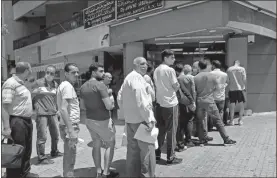  ?? AP-Hussein Malla, File ?? People line up outside an exchange shop to buy U.S. dollars, in Beirut, Lebanon. Lebanon’s financial meltdown has thrown its people into a frantic search for dollars as the local currency’s value evaporates. Long, raucous lines mass outside exchange bureaus to buy rationed dollars.