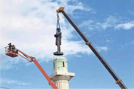  ?? ASSOCIATED PRESS ?? A statue of Confederat­e General Robert E. Lee is removed from Lee Circle in New Orleans in May. The city council voted to remove the monument and three other Confederat­e and white supremacis­t monuments in December 2015.