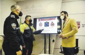  ?? TONI GUDIEL ?? El edil de Interior, con dos agentes de la policía y una imagen de las señales.